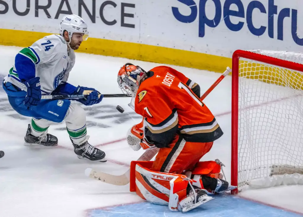Ducks goalie Lukas Dostal, right, blocks a shot as the...