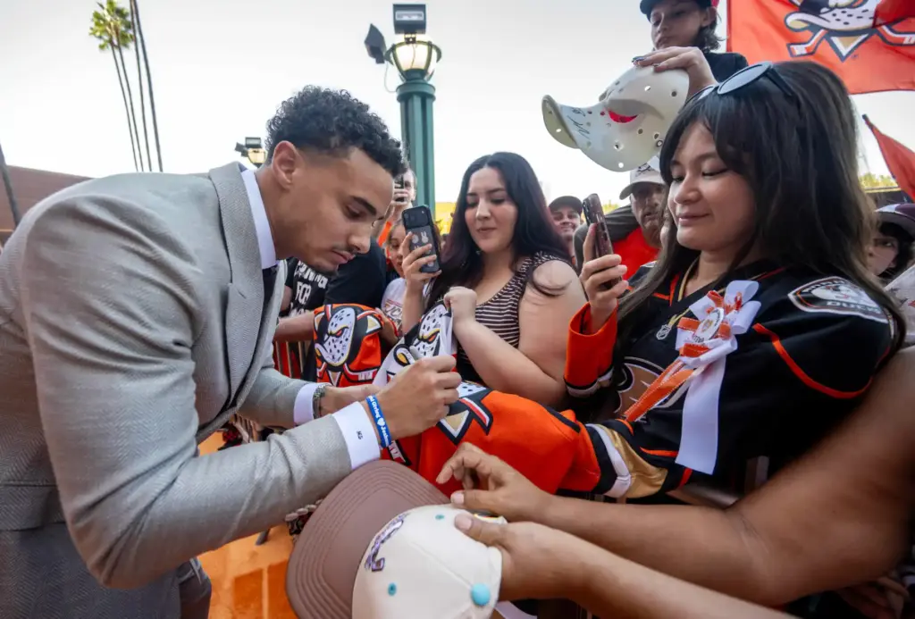Ducks player Tyson Hinds signs autographs on the orange carpet...