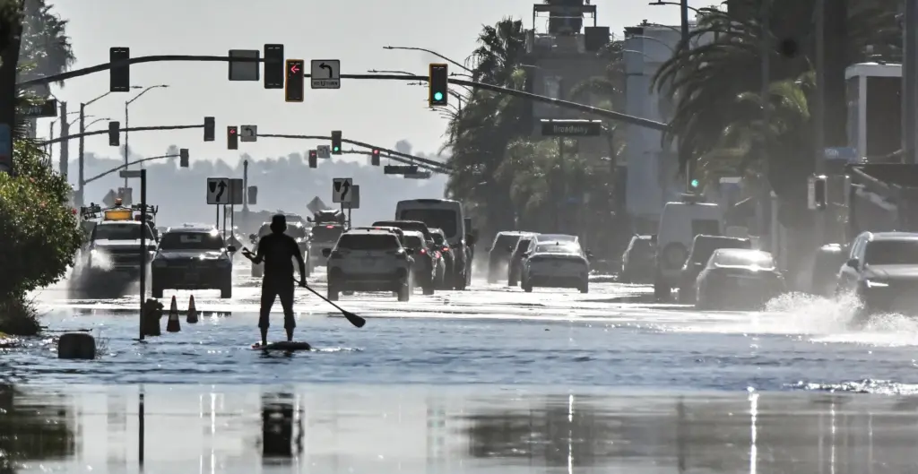 Casey Satchell rides a stand up paddle board as sea...