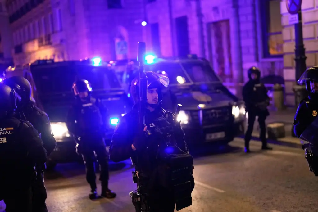 Police officers cordon off the area as protesters gather after...