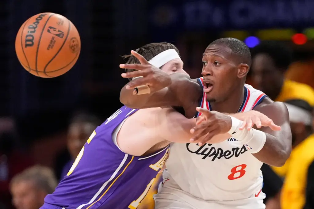 Clippers guard Kris Dunn, right, passes the ball while under...