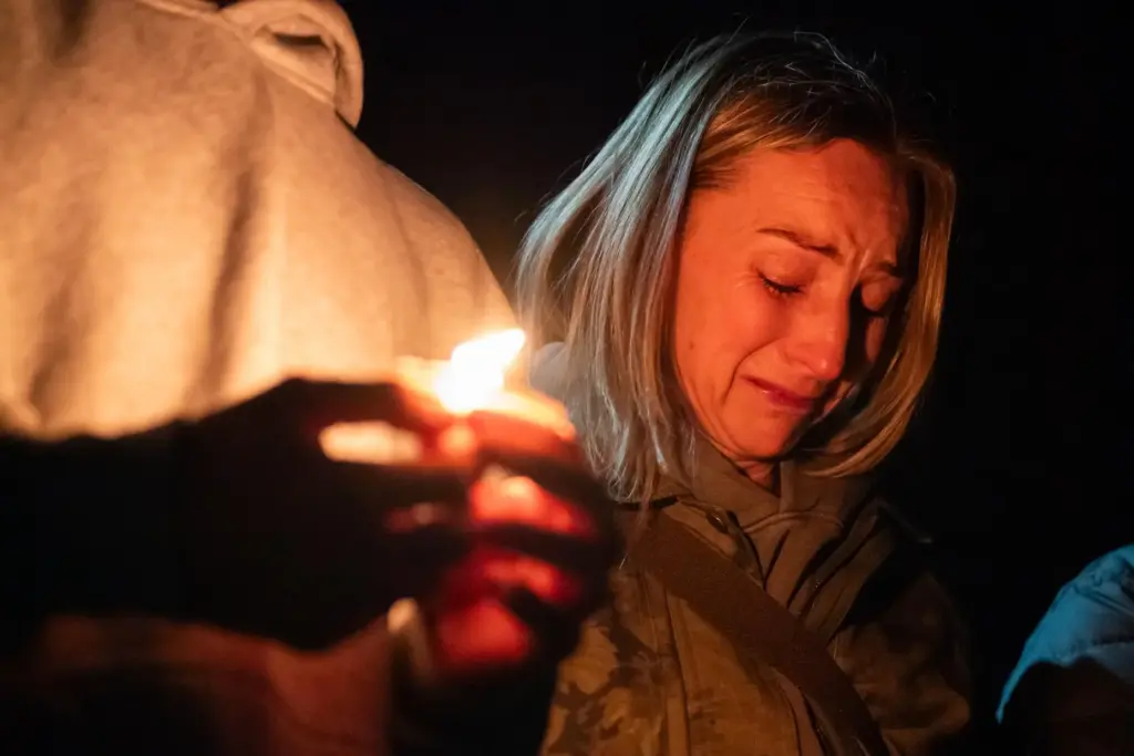 Dara Crawford cries during a candlelight vigil at Drake Park...