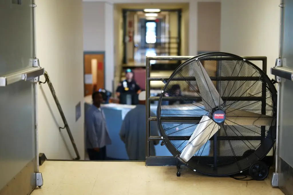 An industrial fan sits in a housing unit at the...