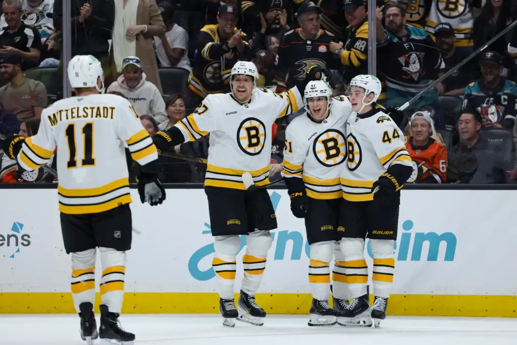 Boston Bruins center Matthew Poitras, third from right, celebrates with,...