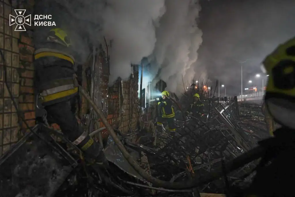 Emergency services personnel work to extinguish a fire following Russian missile attacks.