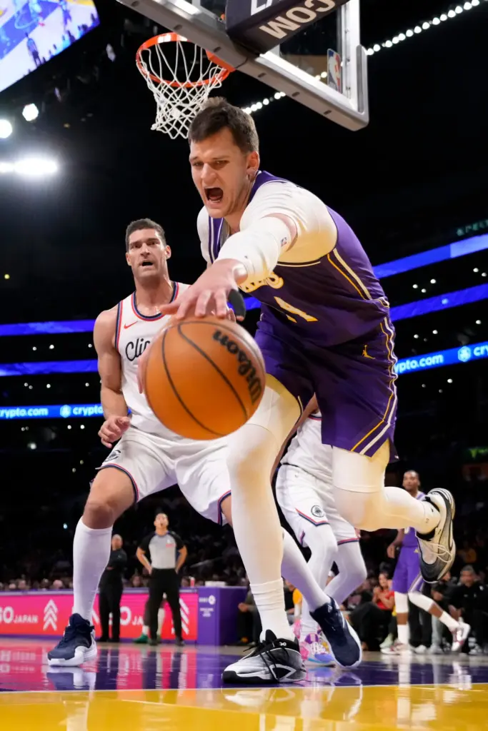Lakers center Walker Kessler, right, reaches for a loose ball...
