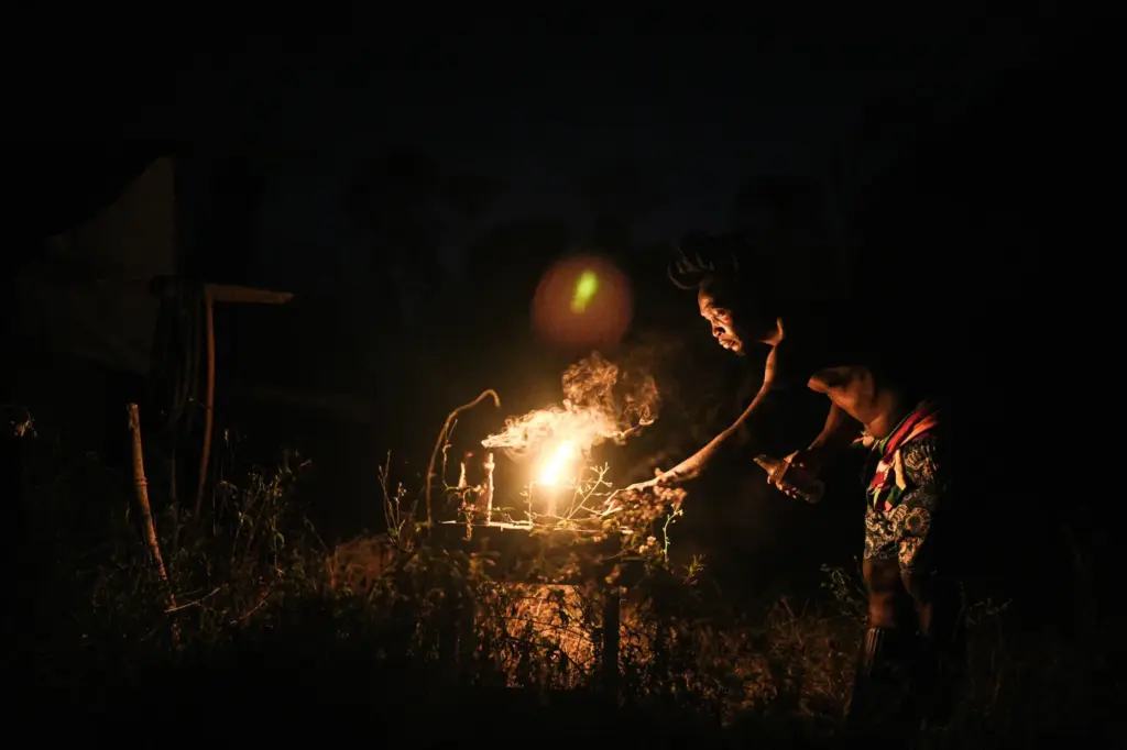 Dennis Adipi, a member of the Saamaka community, lights candles...
