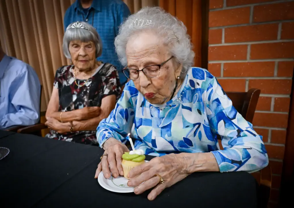 Marilyn Lindley, 101, left, watches as Soula Thomas, 102, blows...