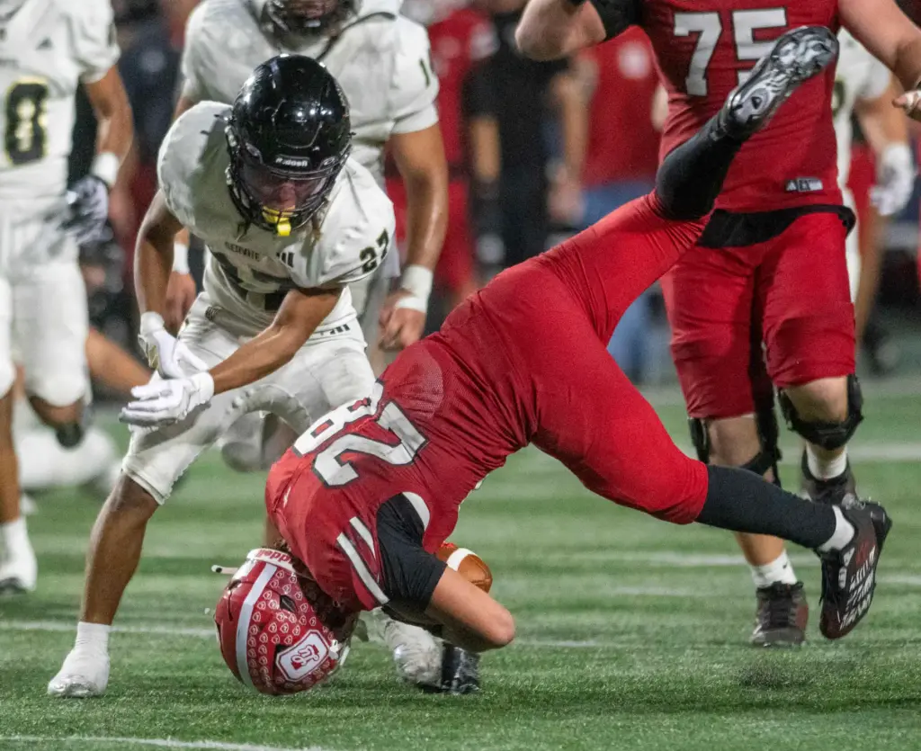 Servitesâ Kenneth Ashley Jr. (27) throws Orange Lutheran’s Ryan Christianson...
