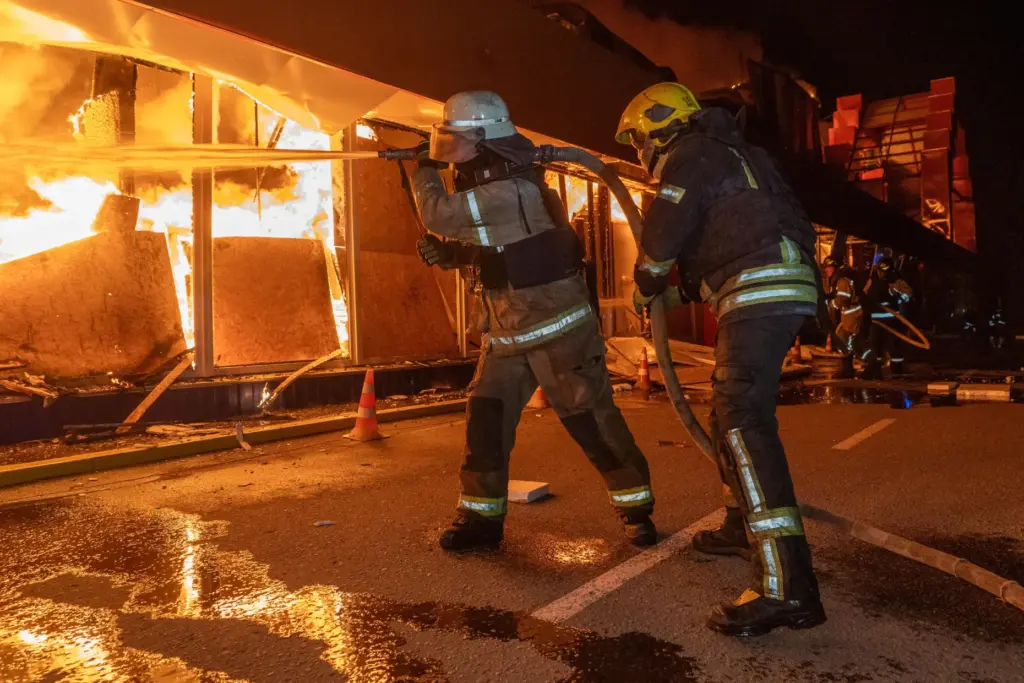 Firefighters try to put out a fire at a shopping...