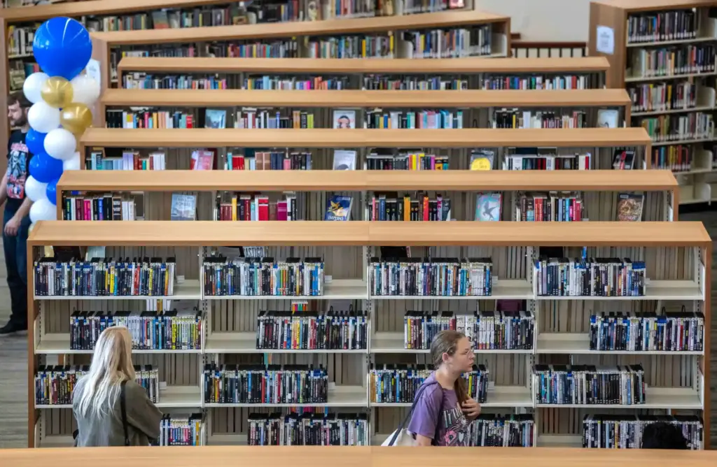 Residents browse bookshelves in the main hall of the Santa...