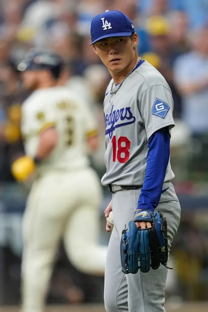 Dodgers starting pitcher Yoshinobu Yamamoto looks toward his dugout after...