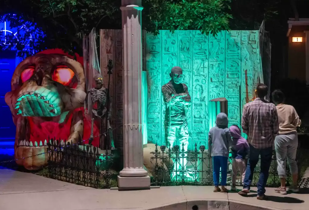 Neighbors walk past a display featuring The Mummy, from the...
