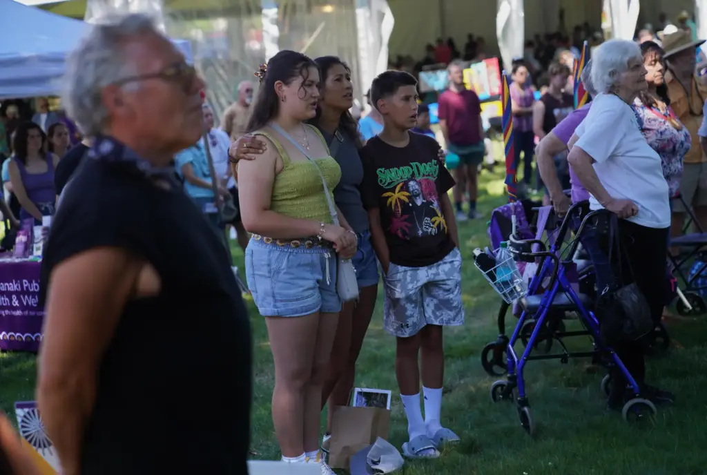 A family sings with a drum circle at the Dawnland...