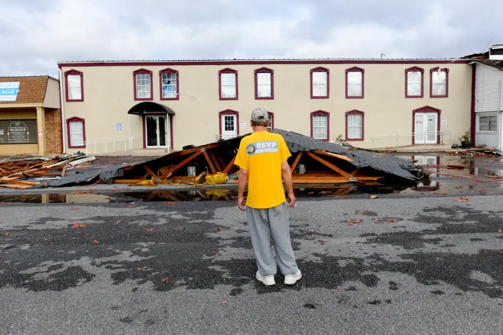 Kenny Smith looks at an apartment roof that was torn...