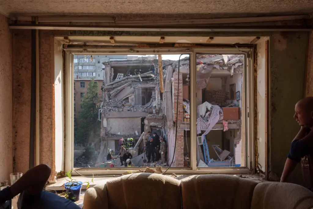 Locals and rescuers clear the rubble of a building destroyed in a Russian missile strike.