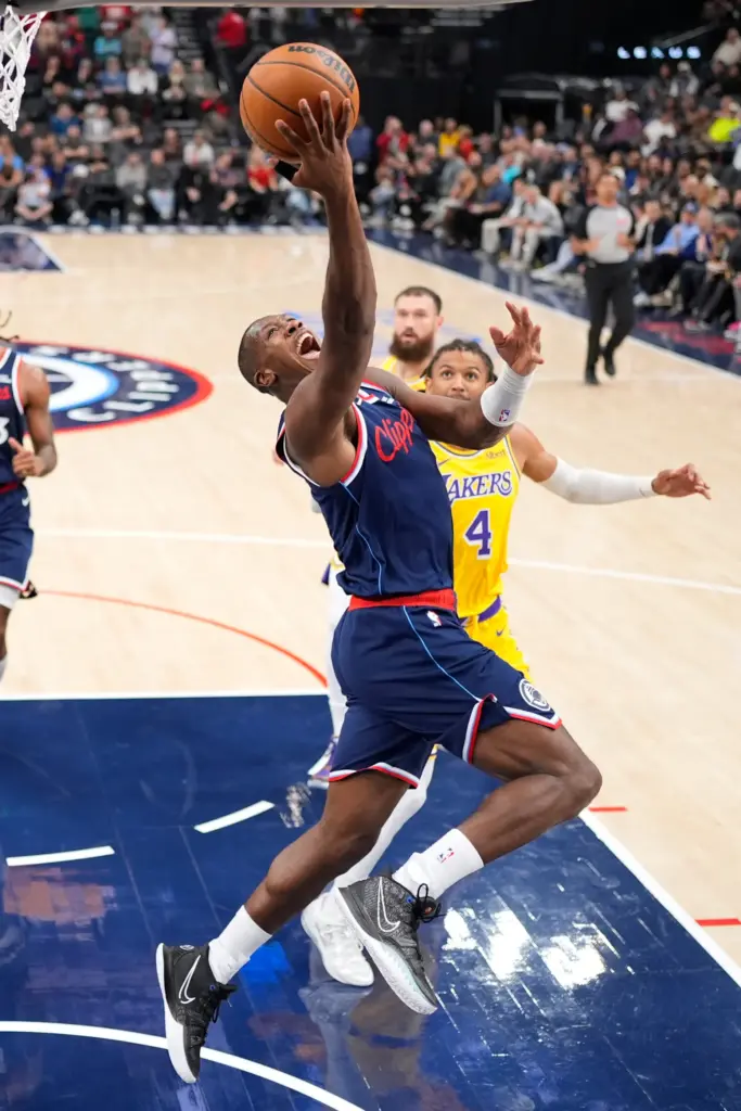 Clippers guard Kris Dunn, left, shoots as Lakers guard Matisse...
