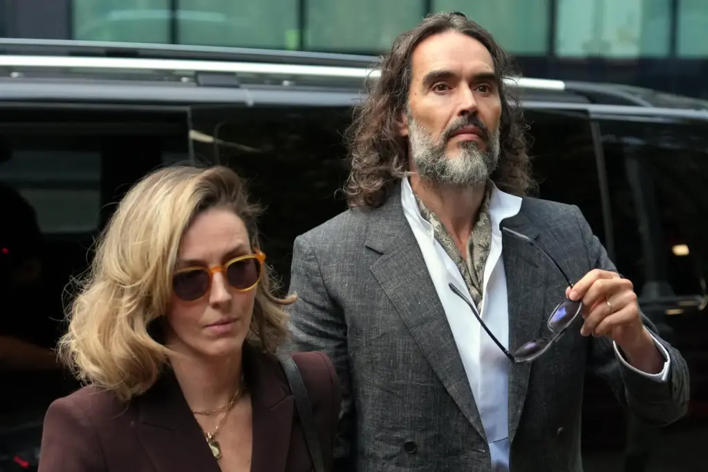 Russell Brand, accompanied by his wife Laura Brand, arrives at Southwark Crown Court.