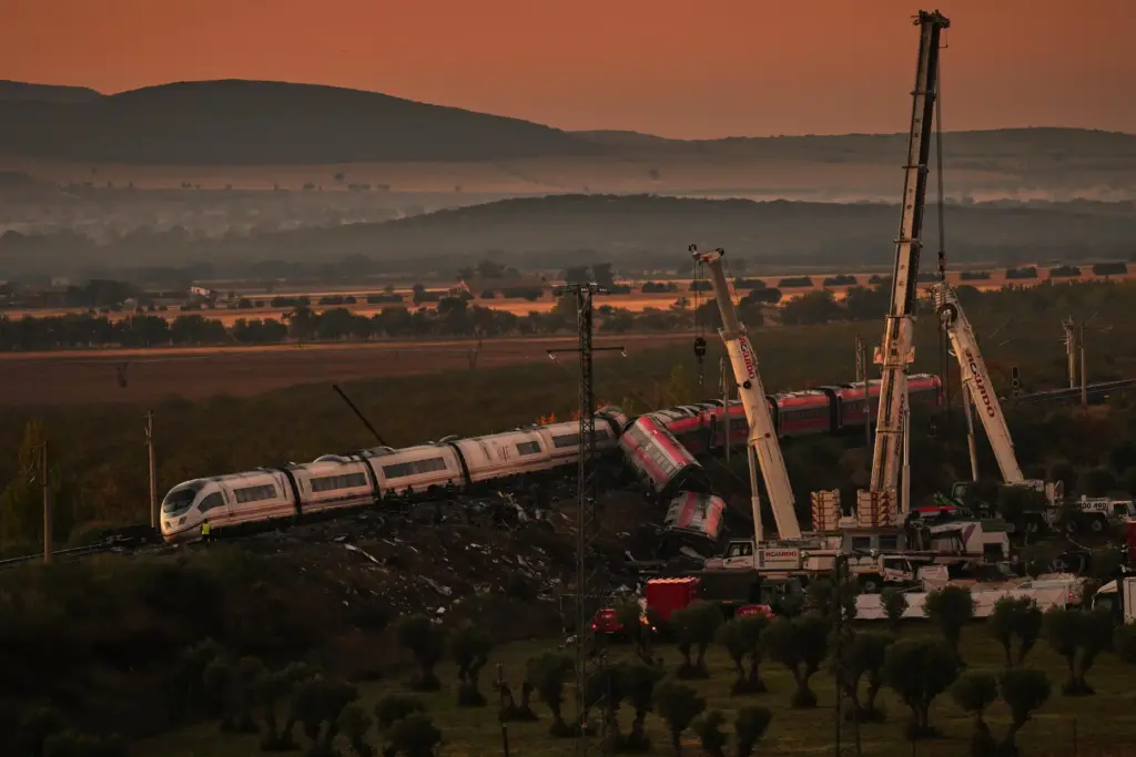 Cranes lift wrecked train carriages as rescuers search for victims...
