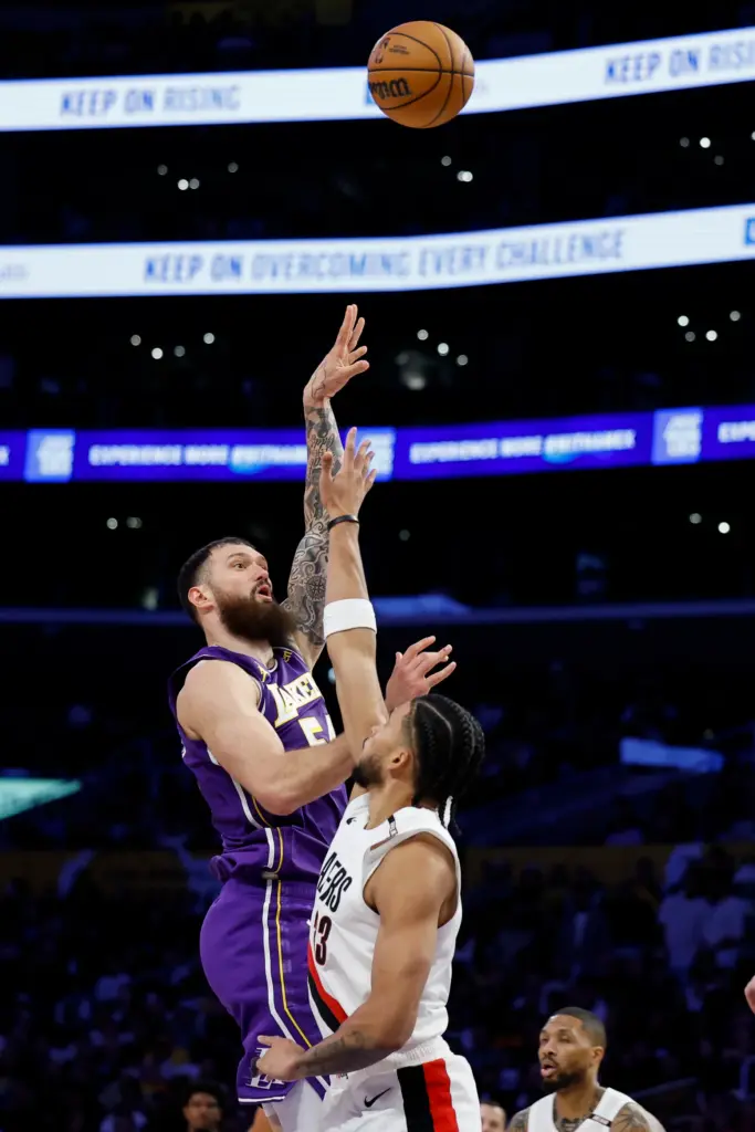 Lakers forward Sandro Mamukelashvili, left, takes a shot as Portland...