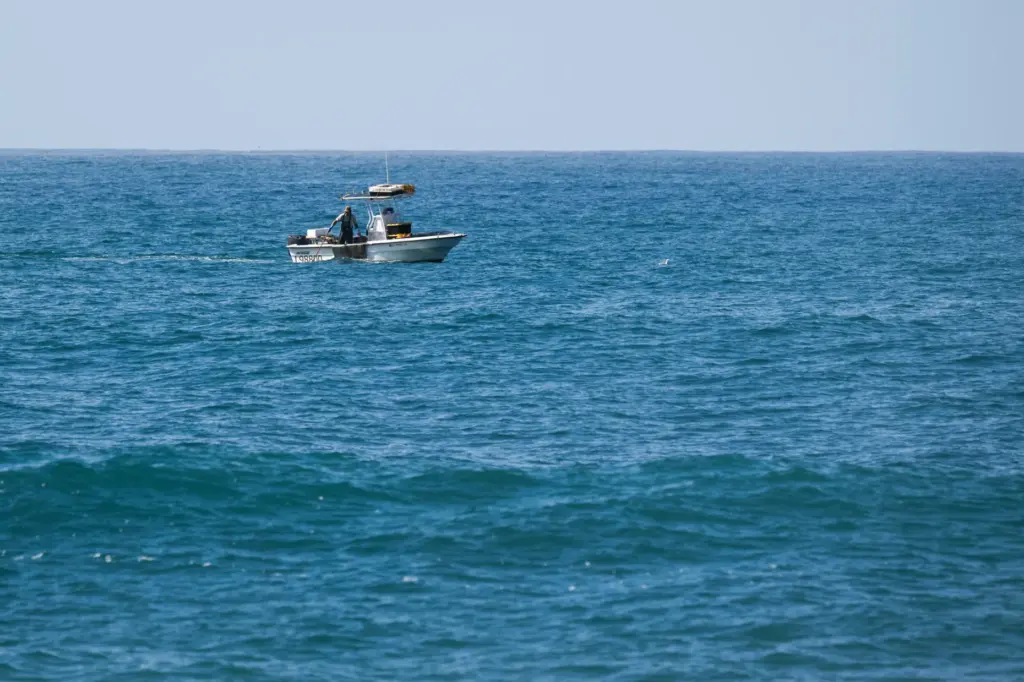 A fisherman works the waters off Thousand Steps Beach in...