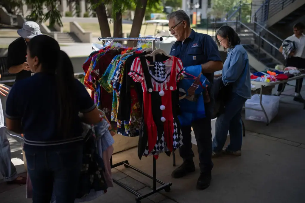 Samuel Hernandez, center, looks for a costume for his grandson...