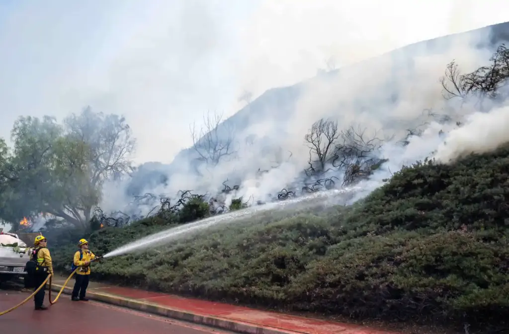 Orange County Fire Authority firefighters spray water on flames on...