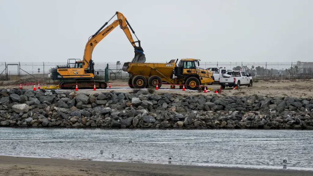 Heavy equipment scoops up loads of sand at the Santa...