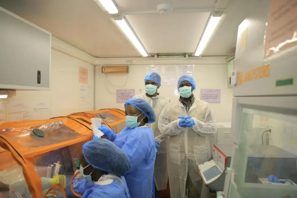 Medical workers work inside a mobile lab set up to test rapidly for Ebola.