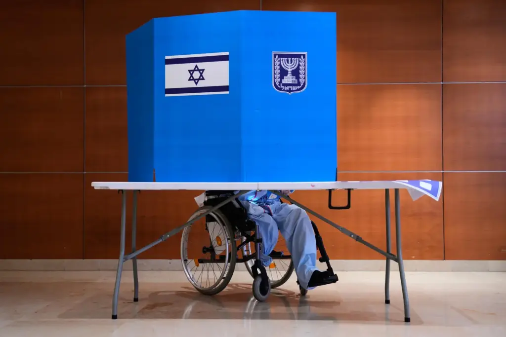 A patient in a wheelchair casts his ballot at a polling station at Rambam Hospital.