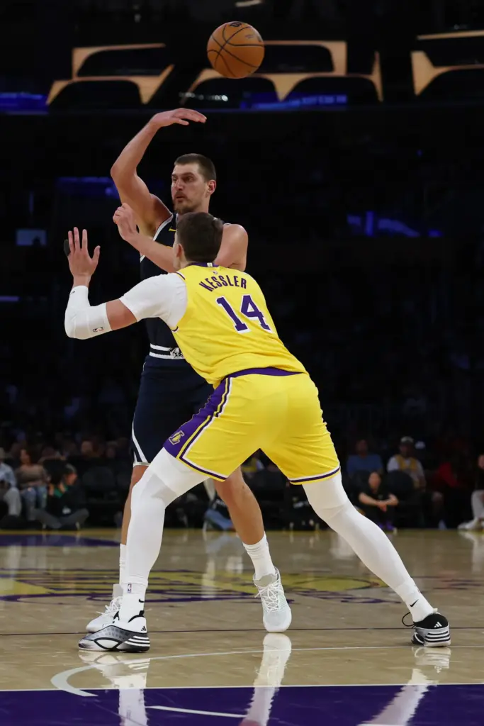 Denver Nuggets center Nikola Jokic, top, passes the ball as...