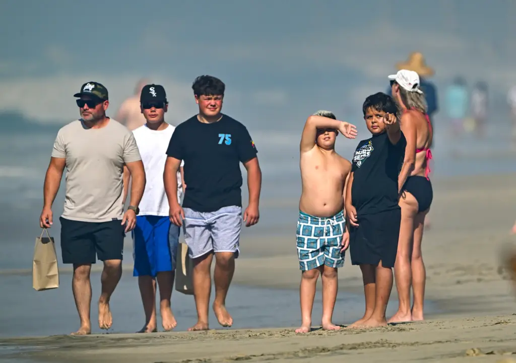 Beachgoers watch the Pacific Airshow in Huntington Beach, CA, on...