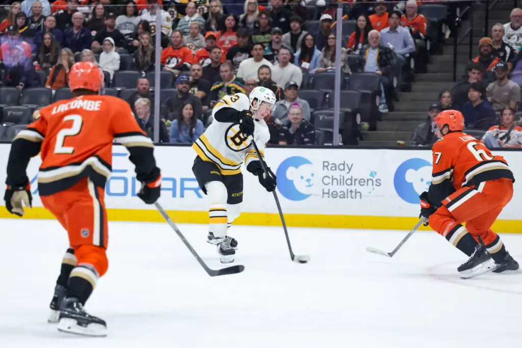 Boston Bruins center Fraser Minten, center, shoots the puck as...