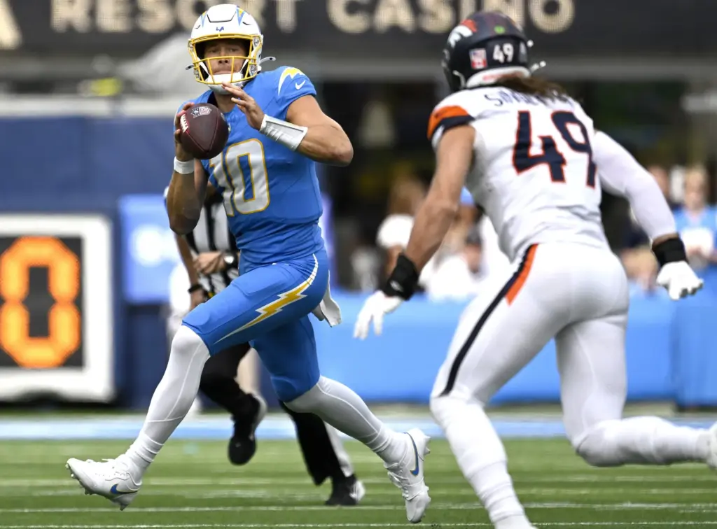 Chargers quarterback Justin Herbert (10) looks to throw down field...