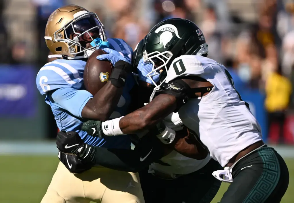 UCLA running back Anthony Woods (6) runs for yardage against...