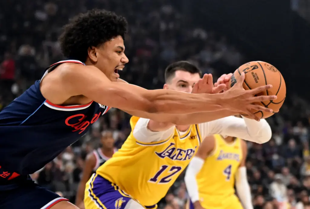 Clippers guard Kobe Sanders, left, reaches for a loose ball...