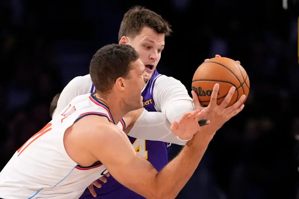 Clippers center Brook Lopez, left, looks to shoot as Lakers...