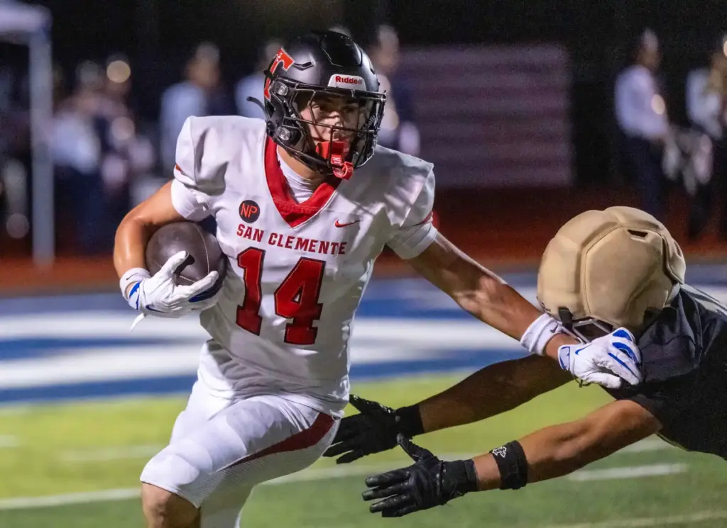 San Clemente wide receiver Jaxson Rex (14) carries the ball...