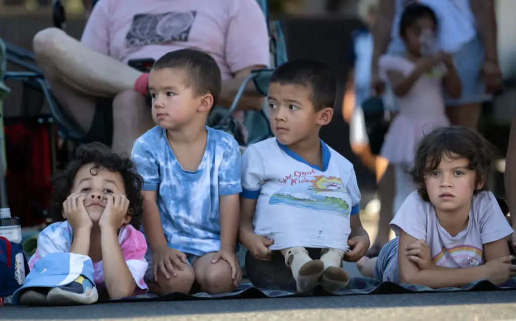 Parade-goers at the Tustin Tiller Days parade make use of...
