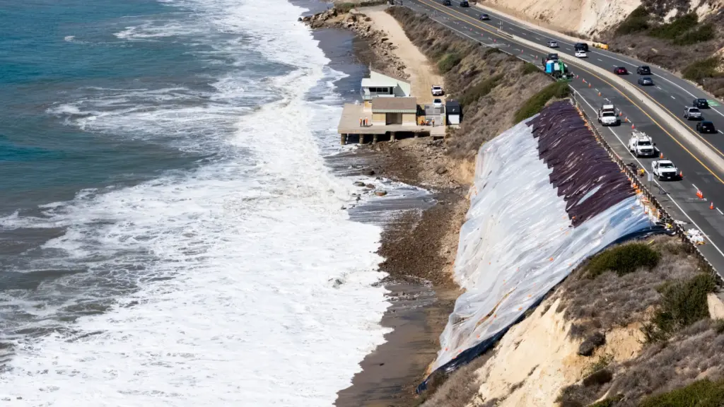 A tarp covers a crumbling bluff along Pacific Coast Highway...
