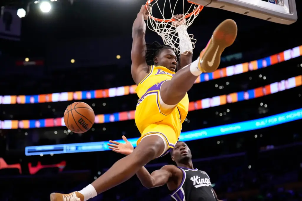 Lakers guard Adou Thiero hangs from the rim after a...