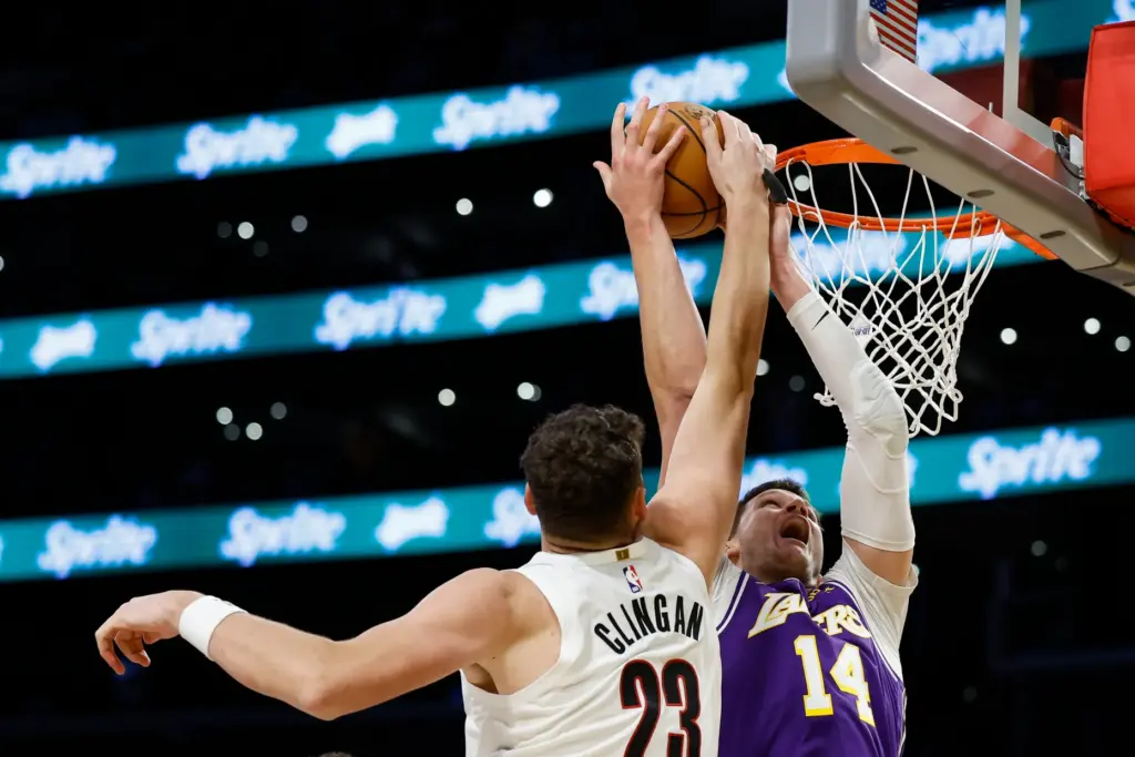 Portland Trail Blazers center Donovan Clingan, left, blocks a shot...