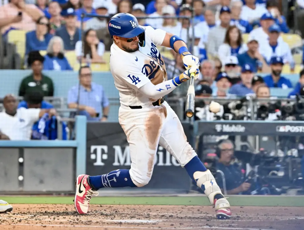 The Dodgers’ Miguel Rojas hits a single during the third...