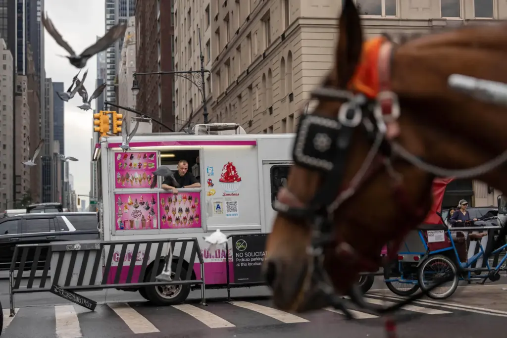 An ice cream vendor peers from his food truck where...