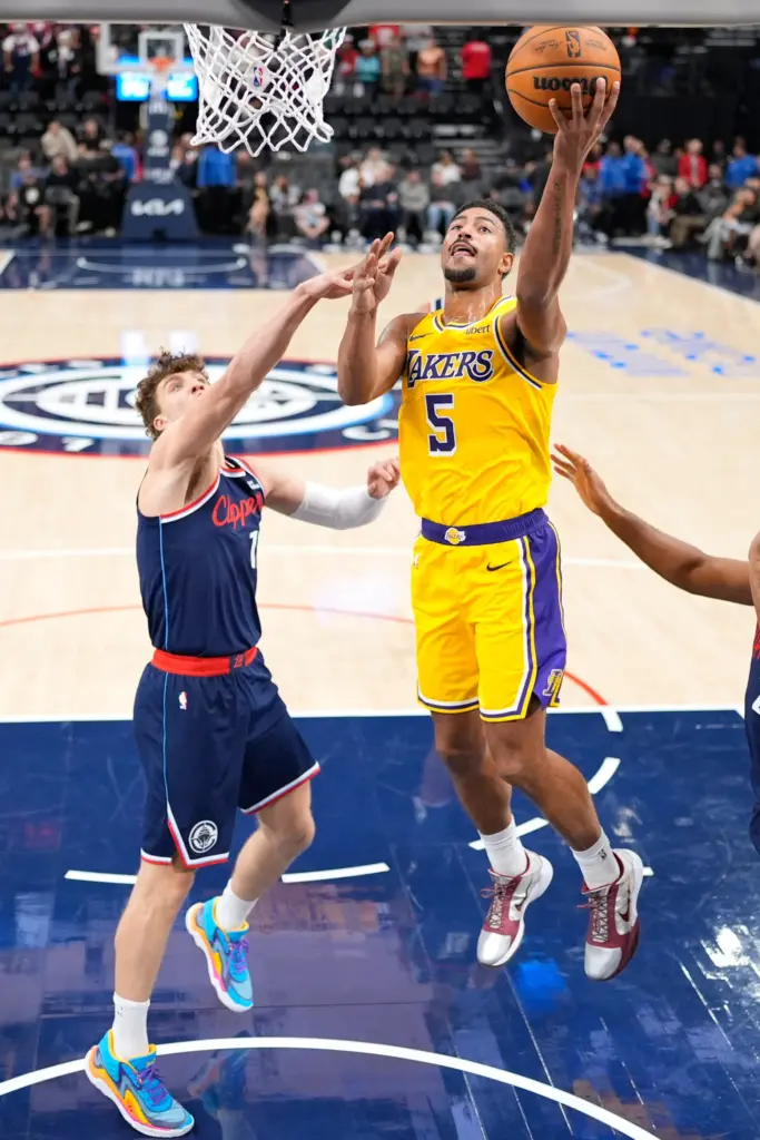 Lakers guard Quentin Grimes, right, shoots as Clippers guard Keaton...