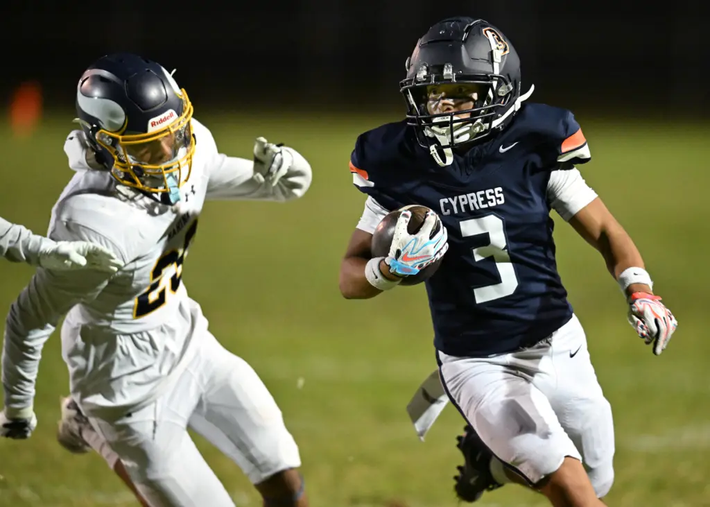 Jayson Bagsic #3 of Cypress runs past Kris Garcia #20...