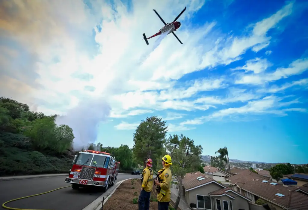 A water dropping aircraft works to save homes during the...