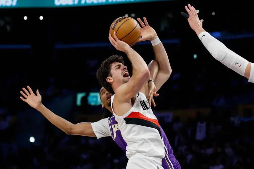 Portland Trail Blazers forward Deni Avdija, front, drives to the...