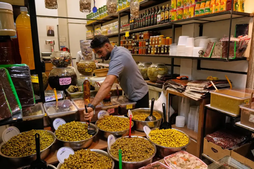 A shopkeeper arranges olives at his shop at Tajrish traditional...