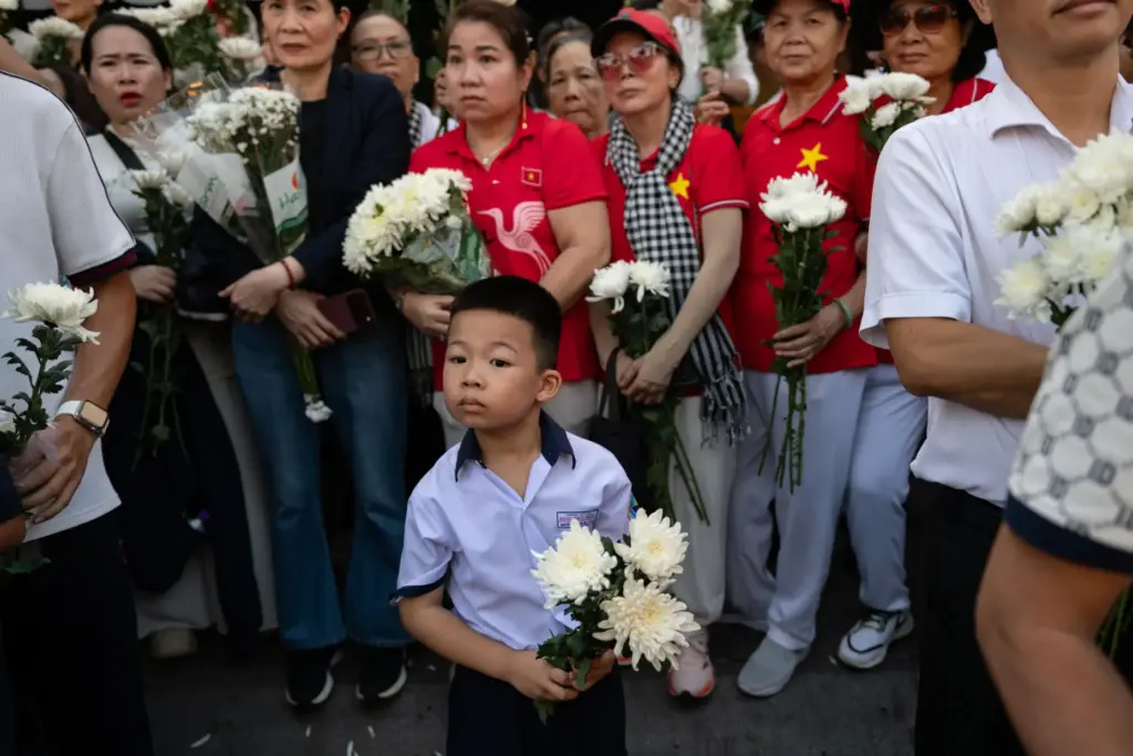 People watch as remains are transferred for burial at Vietnam's Martyr's Cemetery.